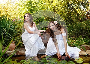 Sisters draw water from a pond.
