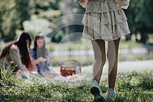 Sisters enjoying a sunny day at the park with a picnic setup and casual attire