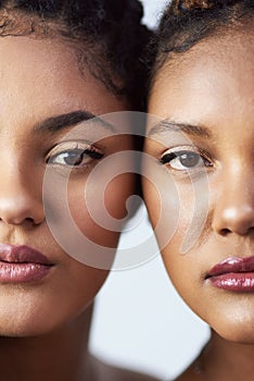 Sisters, half face and beauty in studio, twins and luxury makeup cosmetics on white background. Women, friends and
