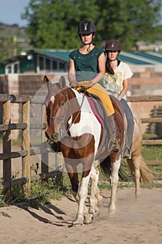 Sisters with happy actitude at a horse riding lesson looking at camera. photo