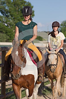 Sisters with happy actitude at a horse riding lesson. photo