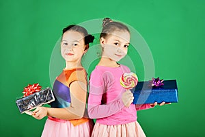 Sisters with lollipops, boxes and bags. Children eat colorful caramels