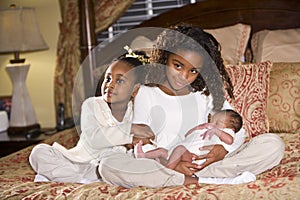 Sisters with newborn sibling