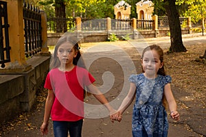 Sisters, Outdoor photo from two little girls. Two little girls walk in the park by the hand. Girlfriends, children