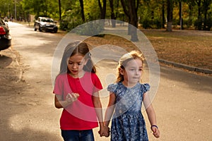 Sisters, Outdoor photo from two little girls. Two little girls walk in the park by the hand. Girlfriends, children