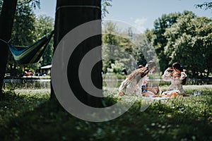 Sisters painting in a park during a picnic on a sunny summer day