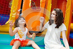 Sisters playing with bubble wand