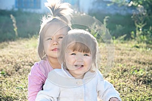 Sisters portrait outdoors at sunny day. happy smiling sibling