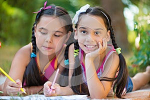 Sisters reading book in summer park