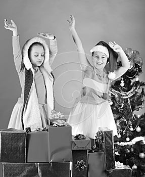 Sisters in Santa Claus hats with New Year tree