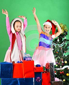 Sisters in Santa Claus hats with New Year tree