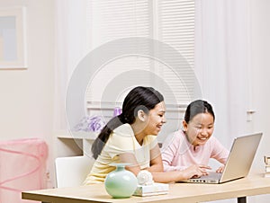Sisters use laptop for internet together
