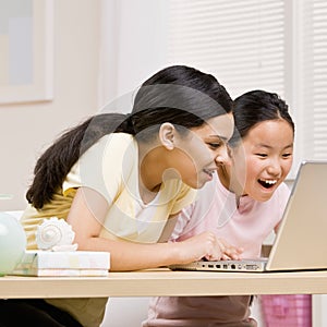 Sisters use laptop for internet together