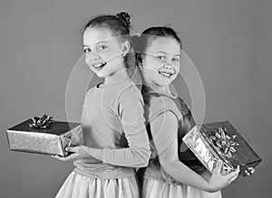 Sisters with wrapped gift boxes for holiday. Children open gifts for Christmas. Girls with smiling faces