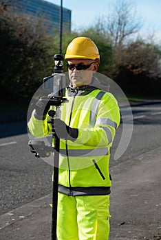 Site engineer doing road survey using modern robotic total station EDM before beginning of construction works