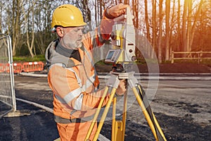 Site engineer setting his instrument during roadworks. Builder installing total positioning station tachymeter on construction