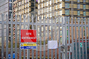 Site entrance sign on fence boundary at construction site