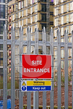 Site entrance sign on fence boundary at construction site