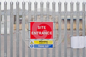 Site entrance sign on fence boundary at construction site