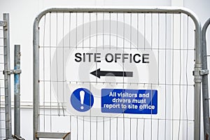 Site office direction sign on construction building site door entrance fence