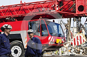 Site workers and giant mobile cranes