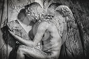 Sitting angel reading stone tablet in black and white background