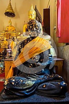 Sitting Black Buddha statue with gold leaf