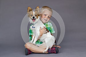 Sitting Boy holding Papillon Dog