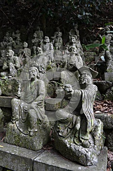 The Sitting Buddha between hundreds of Buddha statues of Japanese style