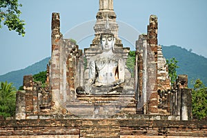 Sitting Buddha statue at the ruins of the main chapel of the Wat Mahathat temple in Sukhotai Historical Park, Thailand.