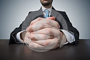 Sitting businessman with clasped hands. Negotiation and dealing concept.