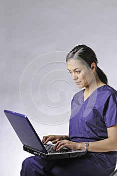 Sitting on chair and typing on the computor.