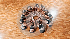 Sitting on circle. Group of female kids practicing athletic exercises together indoors