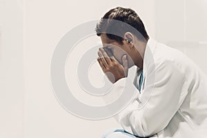 Sitting Frustated Young Doctor in White Uniform.