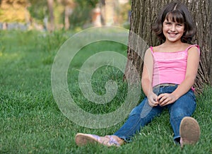 Sitting girl against the tree