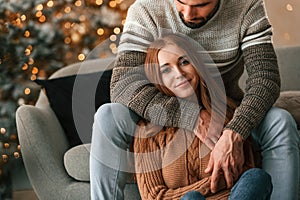 Sitting and looking forward. Lovely young couple are celebrating New Year at home