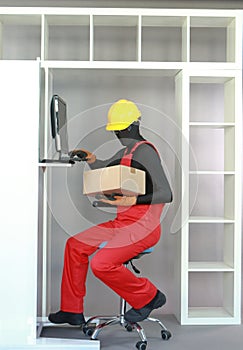 Sitting manual worker dealing with box at computer