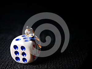 Sitting Mini Figure Toy Man Holding Smartphone at white plastic Dice, Illustration for Online Gamble