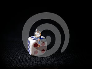 Sitting Mini Figure Toy Man Holding Smartphone at white plastic Dice, Illustration for Online Gamble