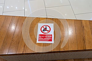 Sitting prohibition or social distance caution sign on wood bench