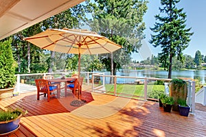 Sitting room area on screened walkout deck with patio table, umbrella and chairs.