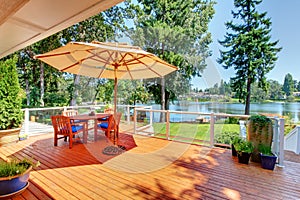 Sitting room area on screened walkout deck with patio table, umbrella and chairs. photo