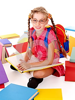 Sitting schoolgirl in eyeglasses with books.