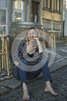 an sitting on the sidewalk at an outdoor cafe on the waterfront.