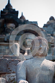 Sitting and smiling Buddha in stone at Borobudur