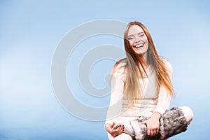 Sitting smiling woman wearing furry shoes