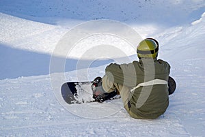 Sitting snowboarder on slope
