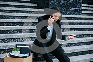 Sitting on Stairs Woman on Phone Discussing Job Loss and Workless Situation