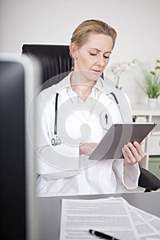Sitting Woman Doctor Browsing at Tablet Computer