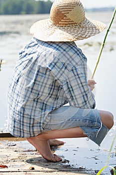 Sitting on wooden bridge barefoot fisherman with